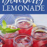 Four glass mugs of sweet blueberry lemonade with ice on a tray for a party.