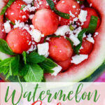 A watermelon bowl carved out and filled with scooped out bowls of watermelon tossed with feta cheese and ribbons of fresh mint.