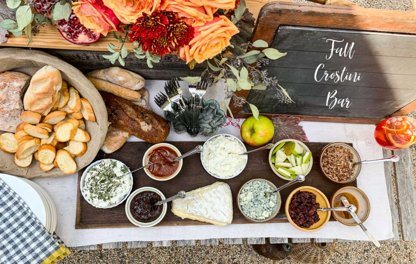 Looking down on a table filled with toppings and crostini toasts at a party.