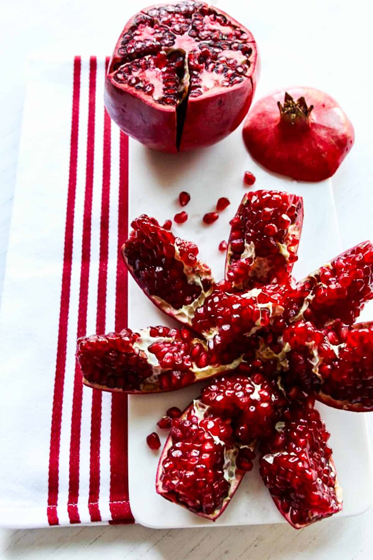 A ripe pomegranate cut open showing the pomegranate arils to use in recipes.