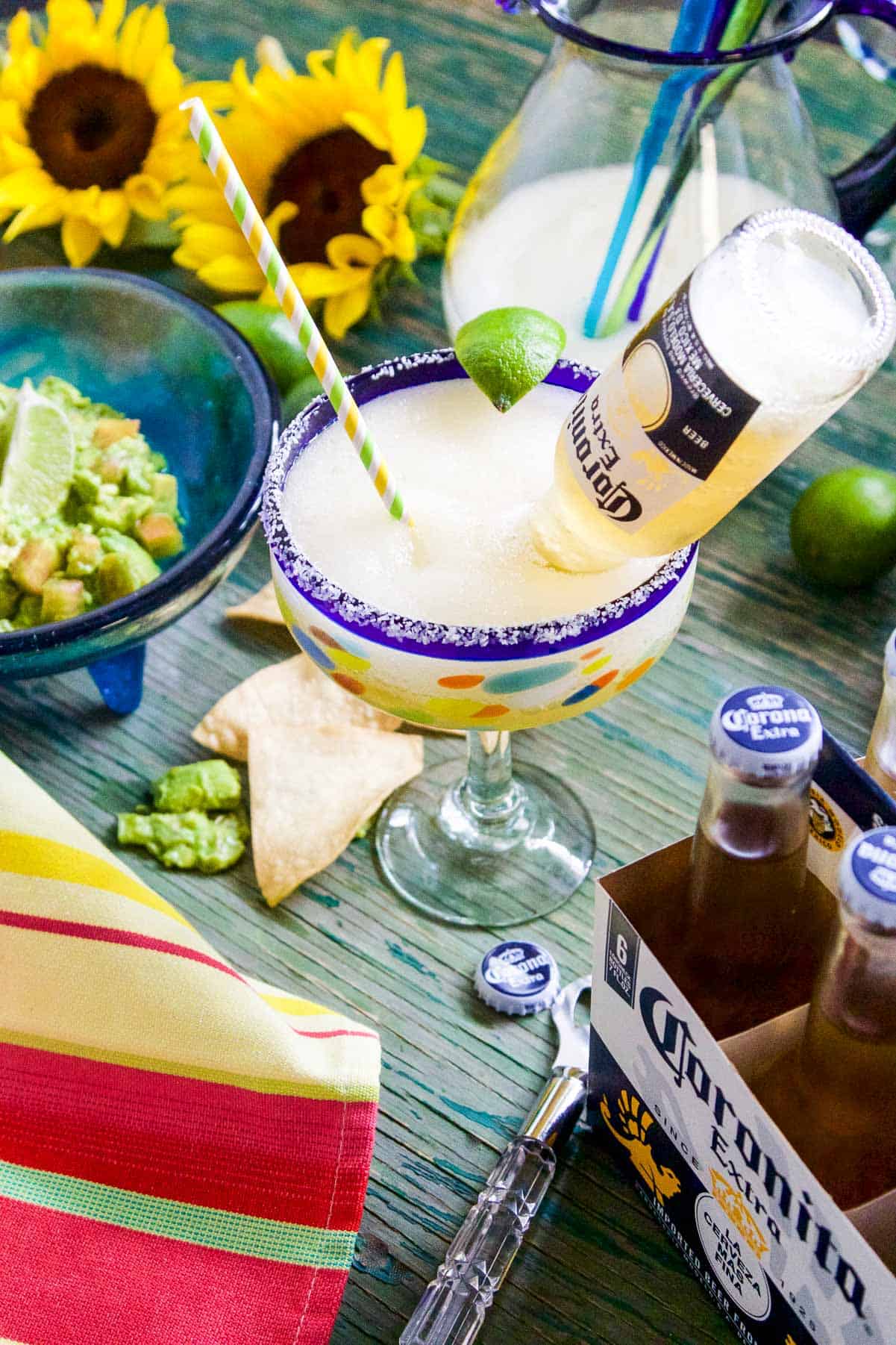 An icy cold slushy margarita with a small Coronita beer inside the glass at a party. 