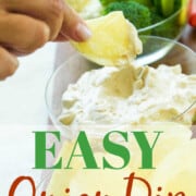 A lady dipping a chip into onion dip at a party.