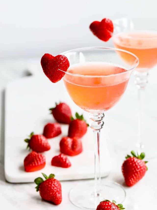 Two strawberry cocktails garnished with strawberry heart shaped garnish.