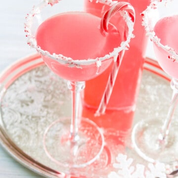 A silver tray with Candy Cane Martinis with crushed peppermint rim and candy cane garnish.