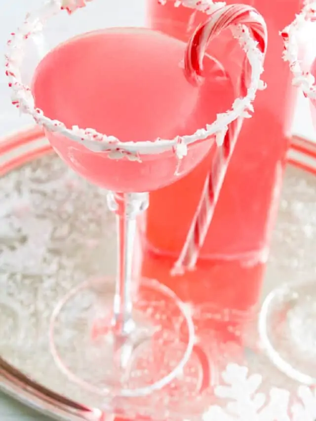 A silver tray with Candy Cane Martinis with crushed peppermint rim and candy cane garnish.