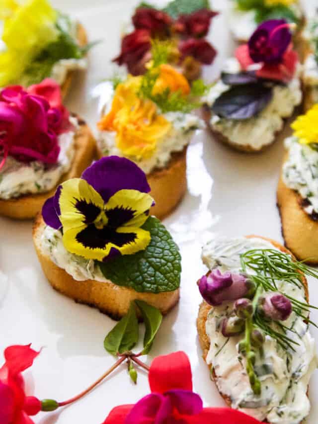 A white platter with crostini recipe topped with edible flowers and herbs.