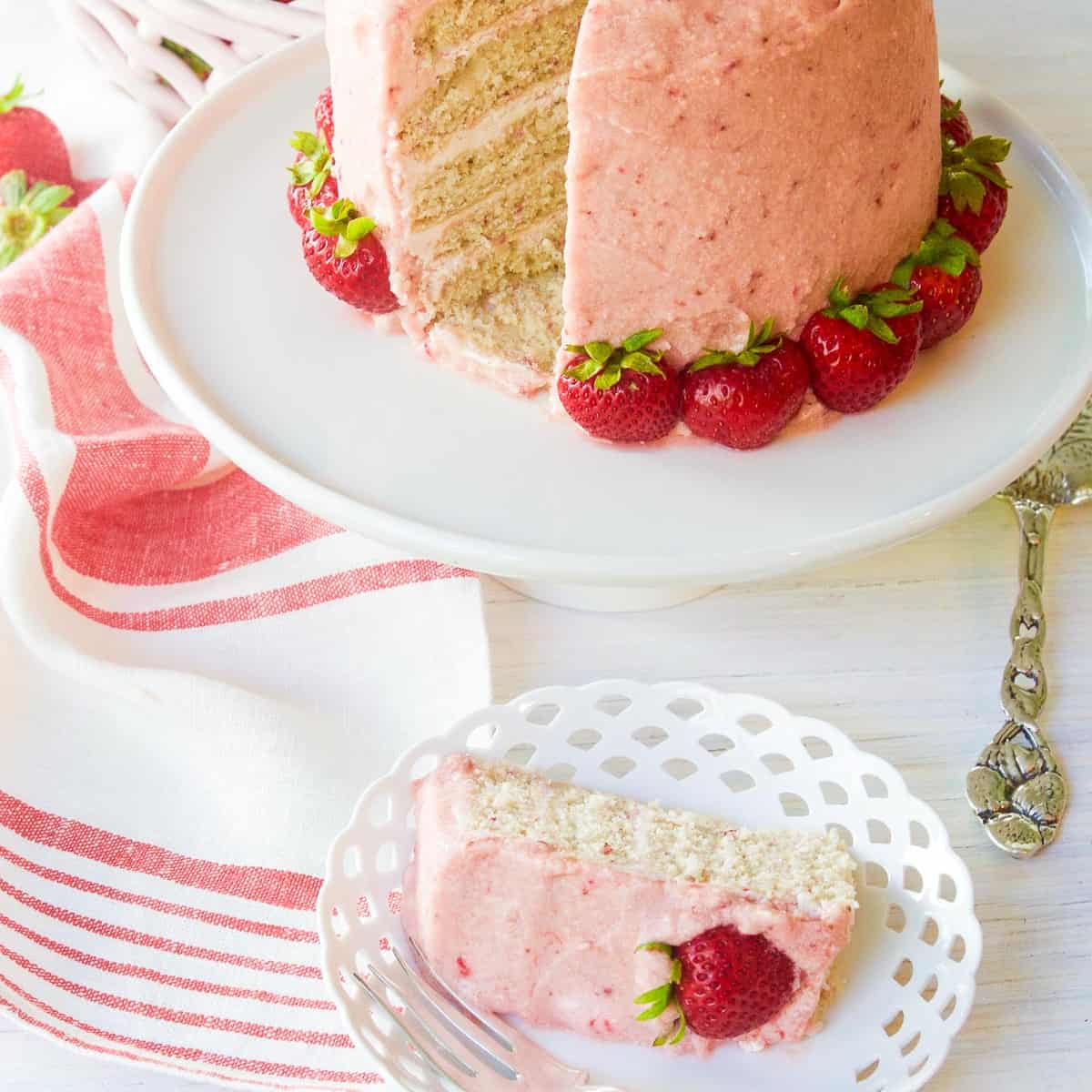 A freshly baked and decorated strawberry cake with real strawberries as decorations.