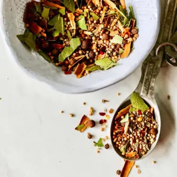 A recipe to make homemade pickling spice in a white bowl.