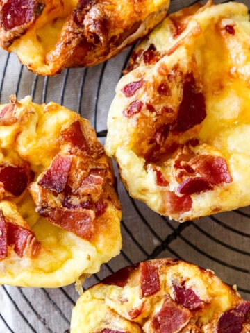 A vintage wire rack with four baked brie and bacon mini quiche.