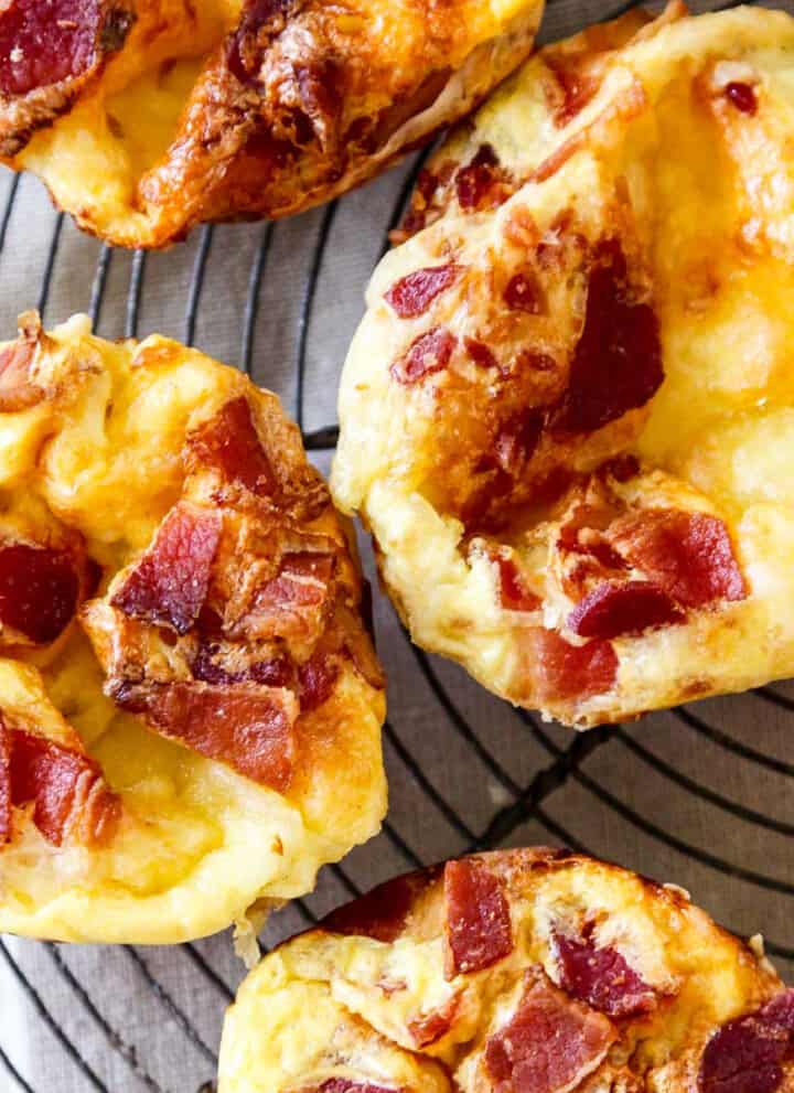 A vintage wire rack with four baked brie and bacon mini quiche.