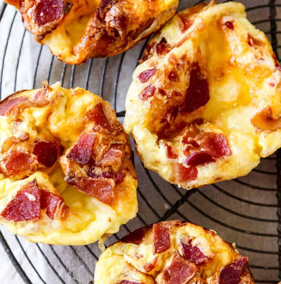 A vintage wire rack with four baked brie and bacon mini quiche.