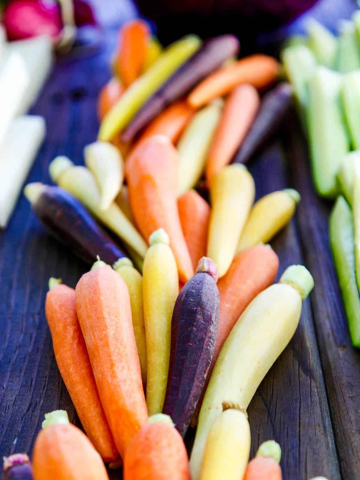 Small orange, yellow and purple carrots cleaned and ready to eat. 