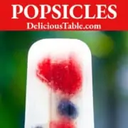 A graphic showing a coconut popsicle with frozen berries inside.