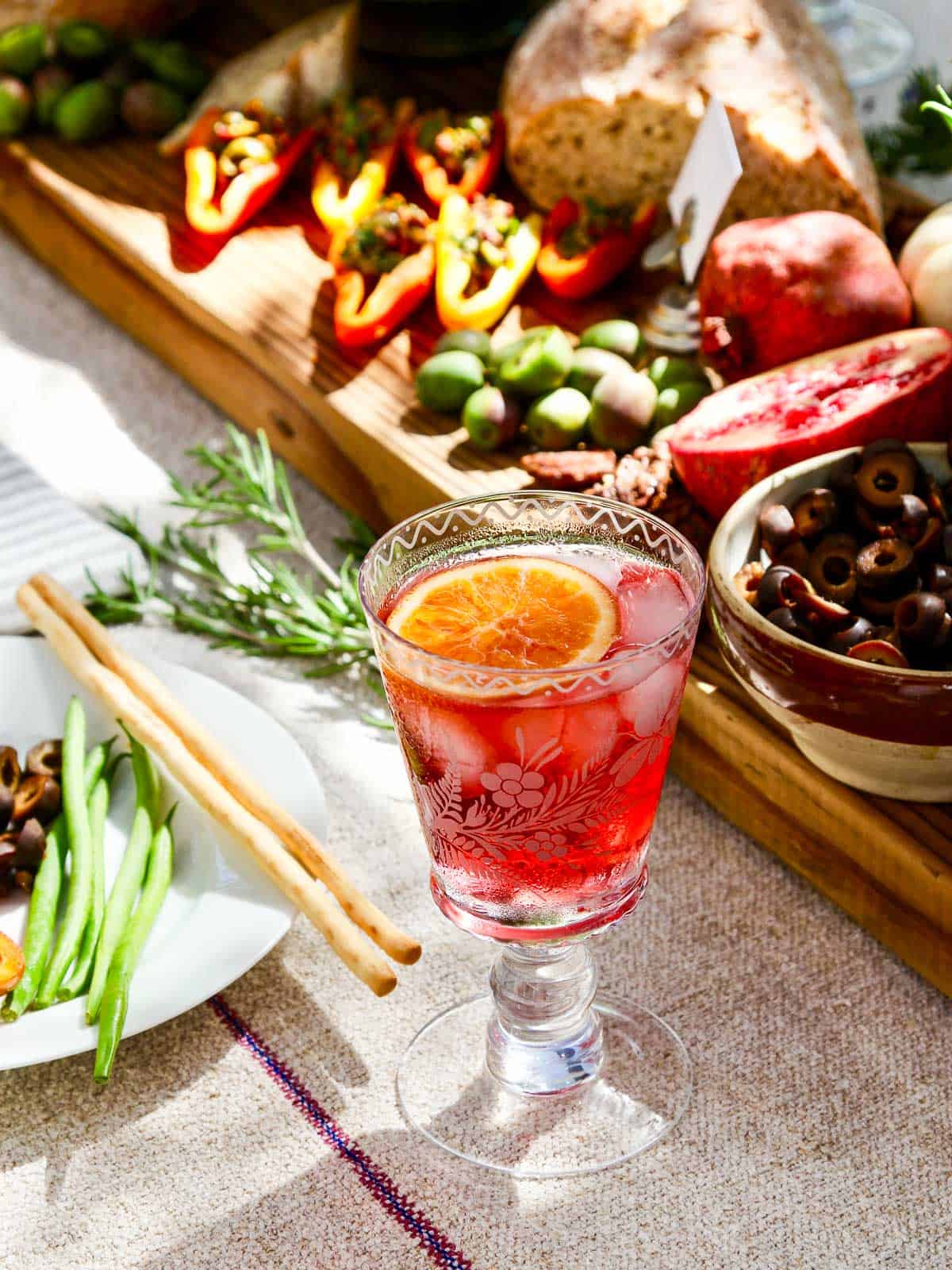 A fancy etched cocktail glass filled with a red hibiscus tea keto cocktail.