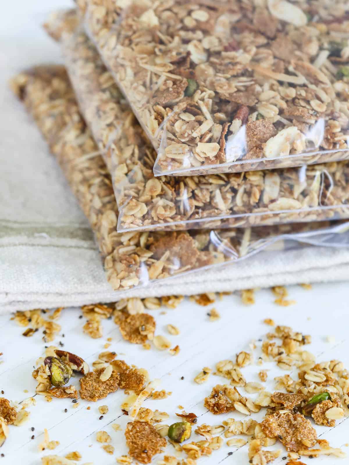 3 zip top bags filled with granola made at home on a beige towel. 