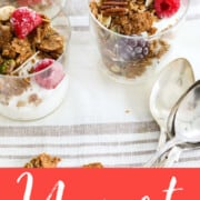 Four yogurt parfaits in small glasses filled with layered yogurt, granola, and fruit.