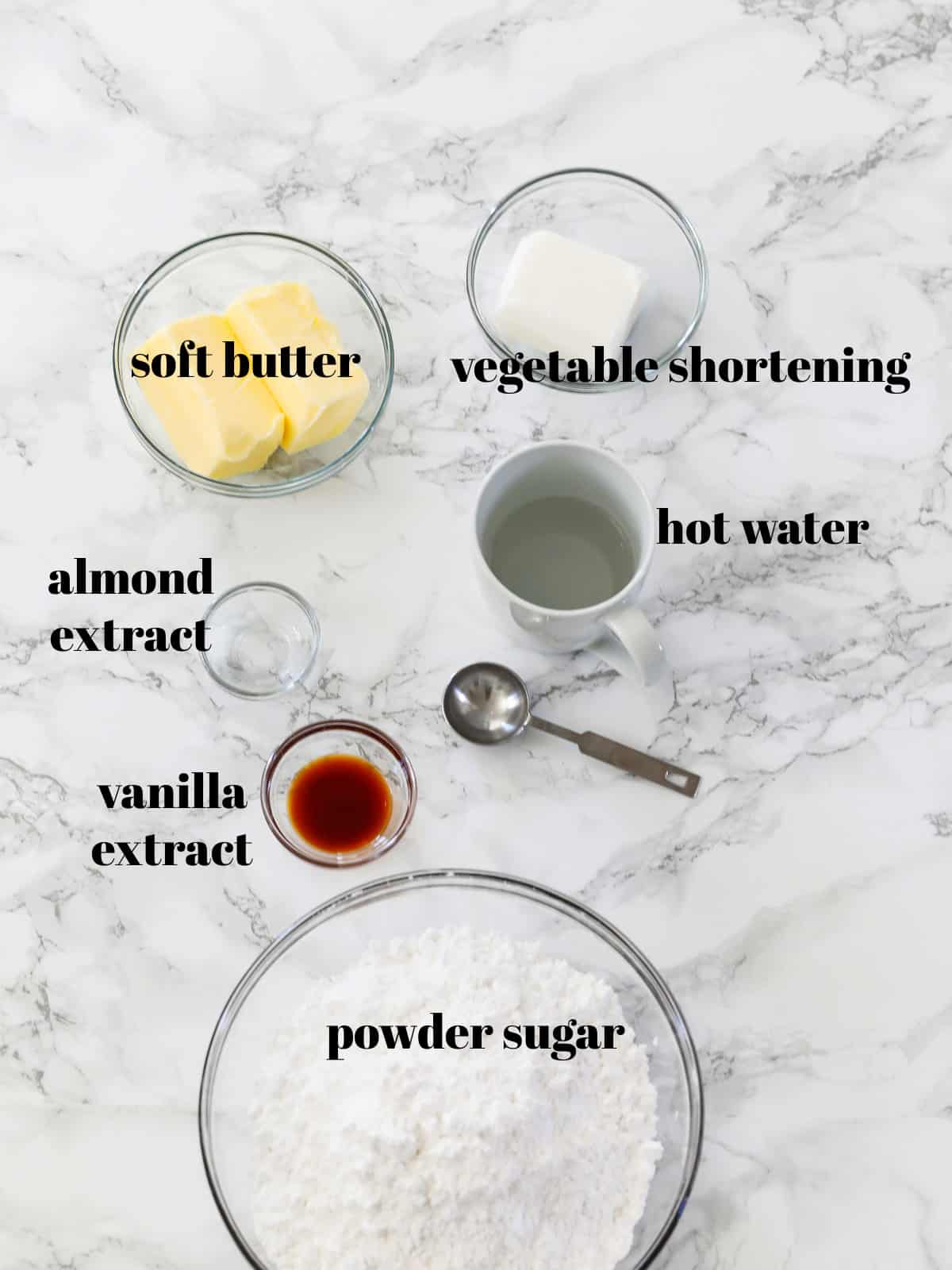 The ingredients to make cake frosting on a countertop labeled including powder sugar, butter, and shortening.