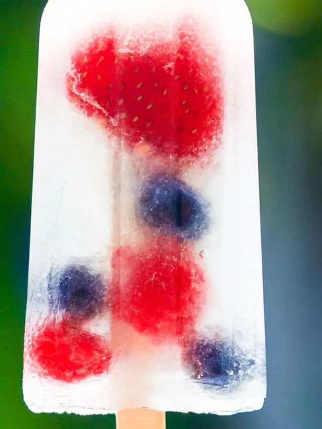 A single coconut water popsicle with strawberries, blueberries, and raspberries.