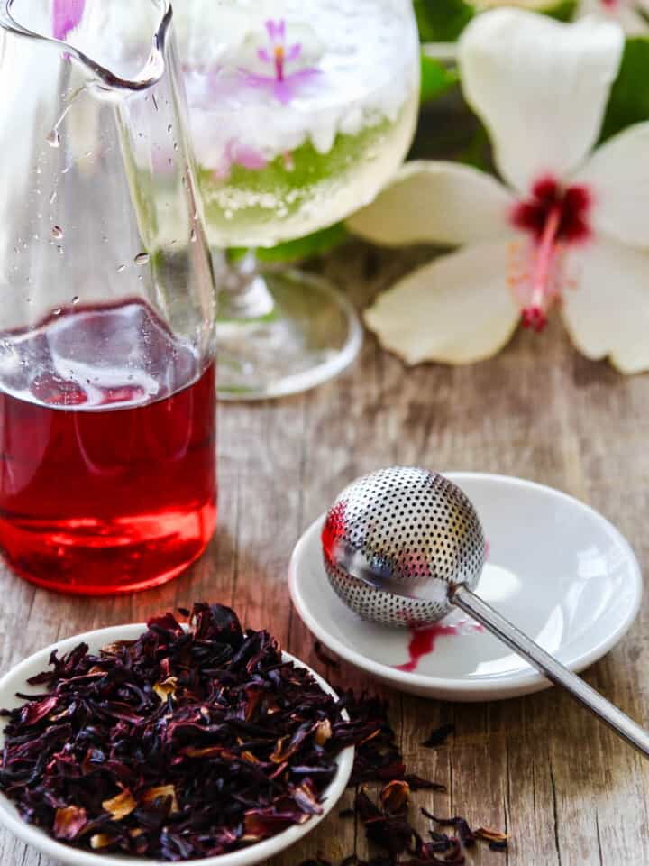 Making hibiscus tea using real tea, a strainer, and hot water.