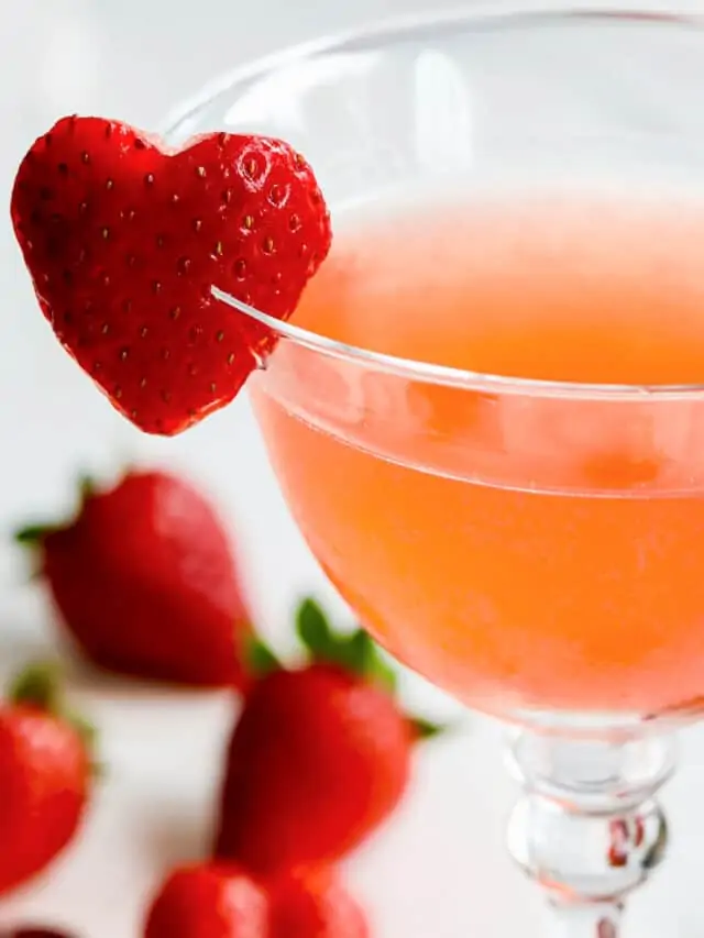 Close up view of strawberry cocktails with heart shaped garnish made from a strawberry on the rim.