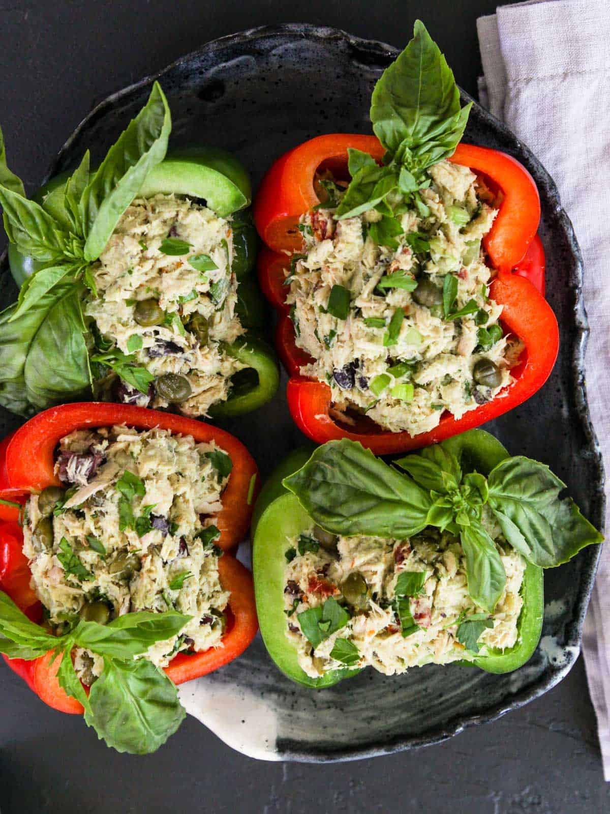 Four Bell Pepper halves filled with Tuna Salad garnished with fresh basil.