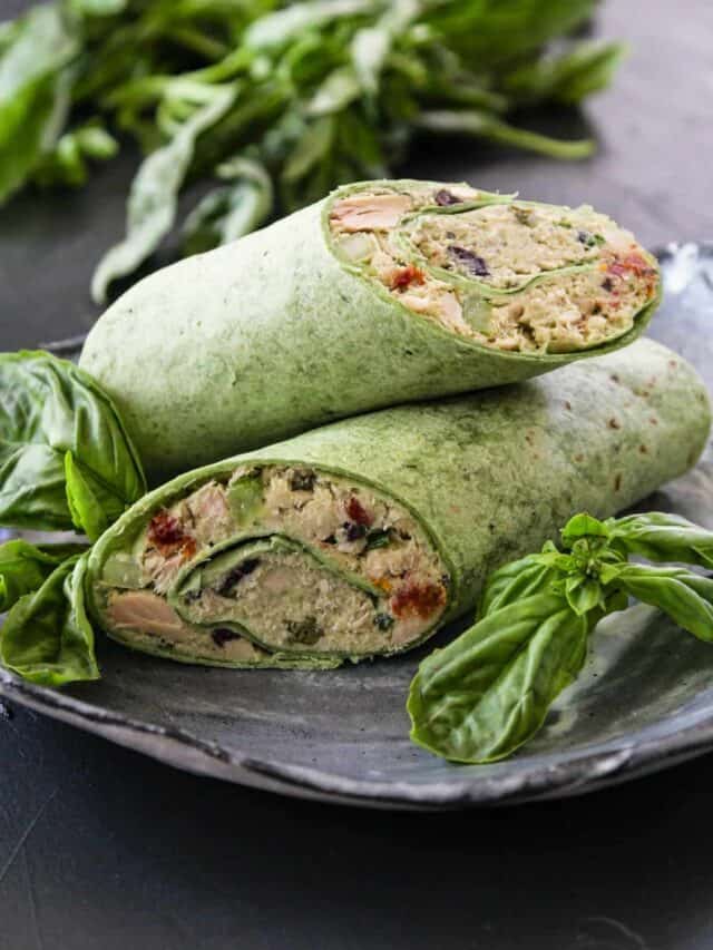 Two green tortilla wraps filled with no mayo Tuna Salad garnished with fresh basil.