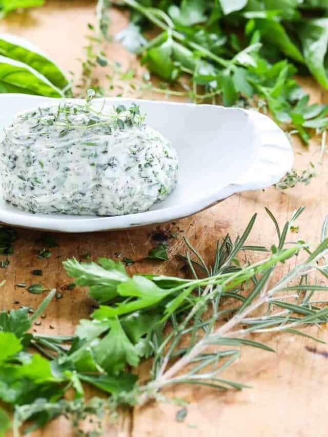 Herb butter made at home with fresh herbs and soft butter in a modern white ceramic dish.