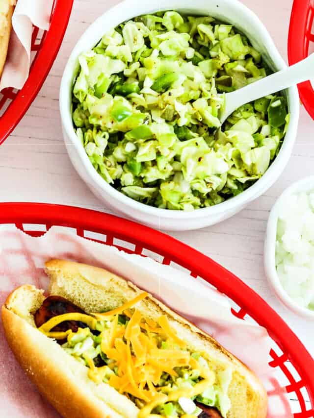 A small white bowl with relish in to top hot dogs in paper lined baskets.