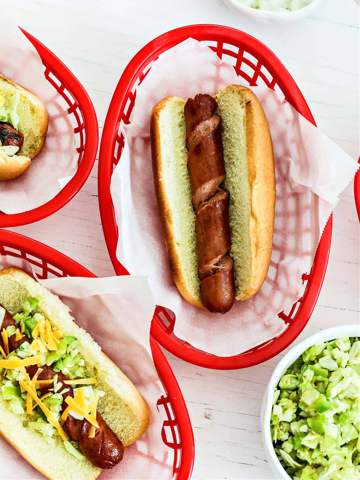 A spiral hot dog on a bun in a red paper lined basket.