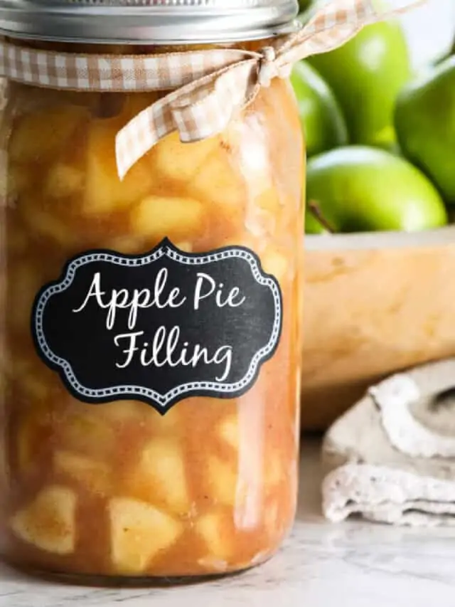 A large jar filled with apple pie filling with a lid and bow.