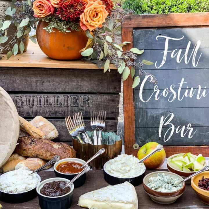 A rustic table with small bowls filled with toppings for a fall appetizer crostini bar.