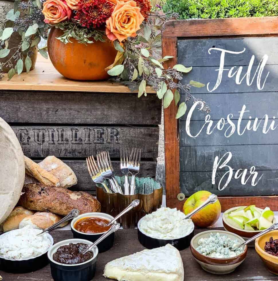 A rustic table with small bowls filled with toppings for a fall appetizer crostini bar.