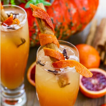 Fireball Whisky Cocktails with cinnamon sticks wrapped in orange peel for garnish.