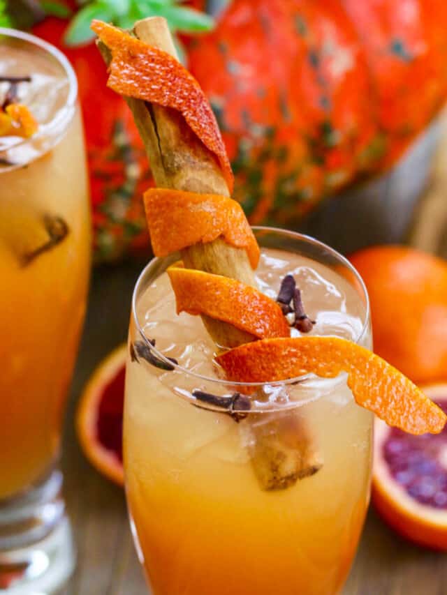 Fireball Whisky Cocktails with cinnamon sticks wrapped in orange peel for garnish.