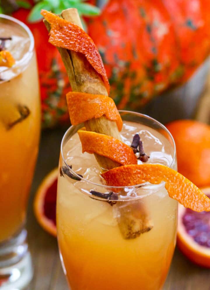 Fireball Whisky Cocktails with cinnamon sticks wrapped in orange peel for garnish.