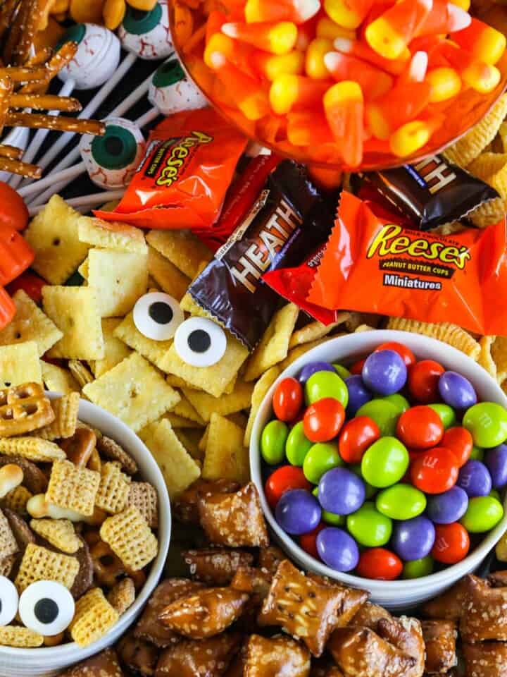 A variety of sweet and salty Halloween Snacks with candy eyeballs.