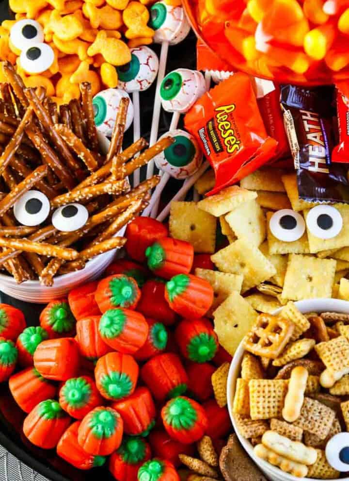 A full platter of Halloween salty snacks and candy decorated with candy eyeballs for an easy last minute Halloween Party Idea.