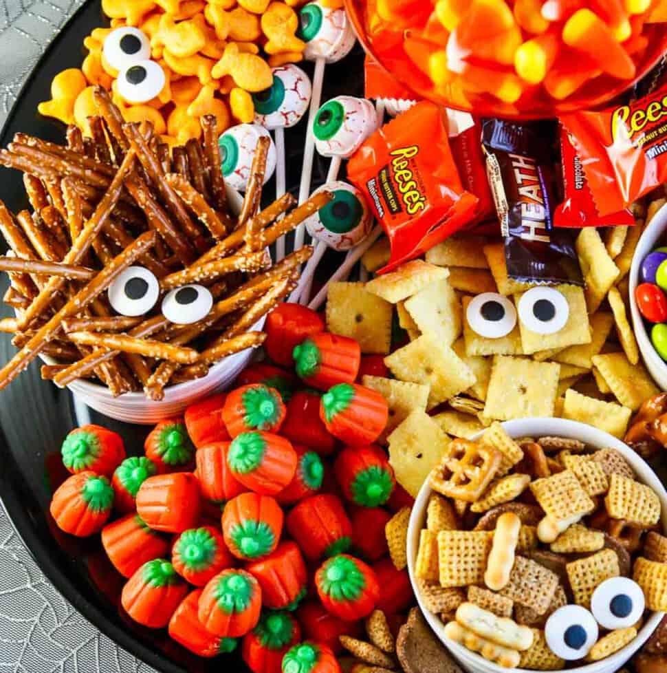 A full platter of Halloween salty snacks and candy decorated with candy eyeballs for an easy last minute Halloween Party Idea.