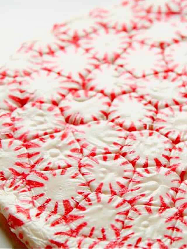A red and white peppermint candy plate made from melted candy in a round shape.