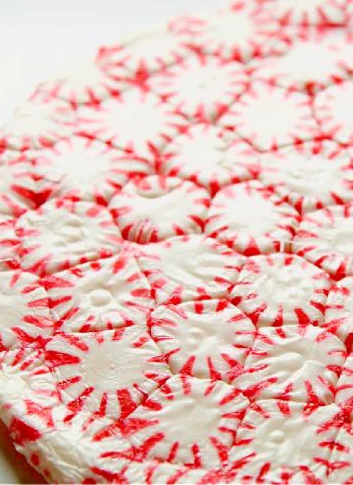 A red and white peppermint candy plate made from melted candy in a round shape.