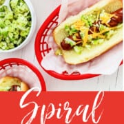 A graphic for Spiral Grilled Hot Dogs in a red plastic food basket loaded with toppings.