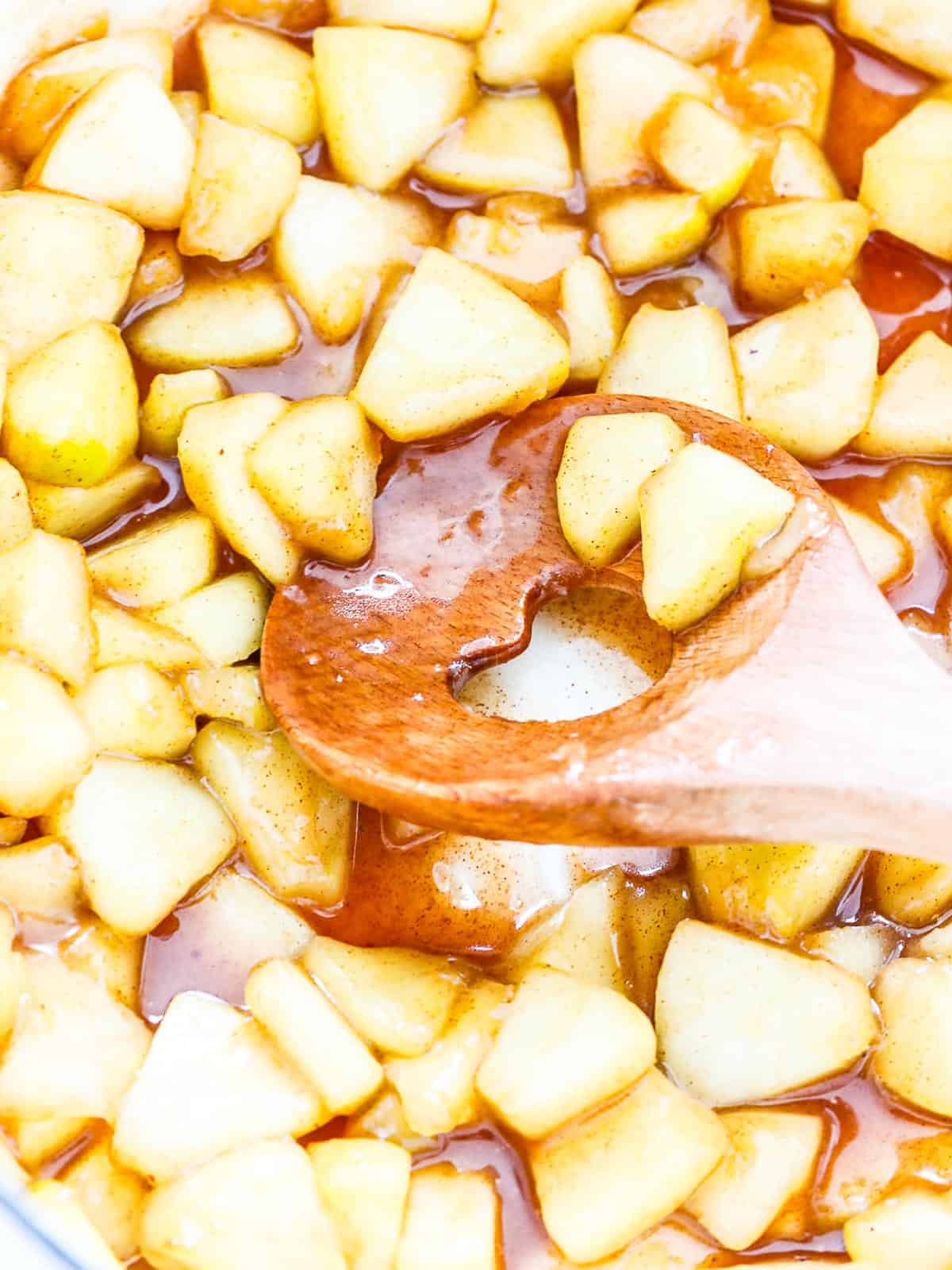 Cooking apple pie filling in a stainless skillet.