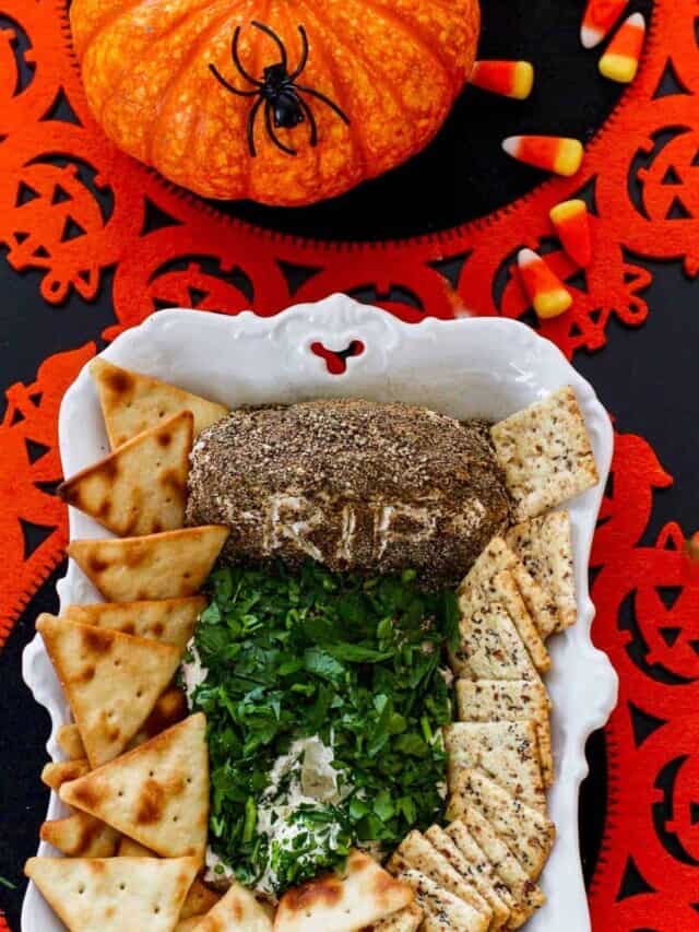 A small white dish with a Halloween dip that looks like a tombstone in a graveyard.