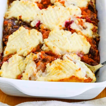 A white dish filled with golden bubbly turkey shepherd's pie baked and ready to eat.