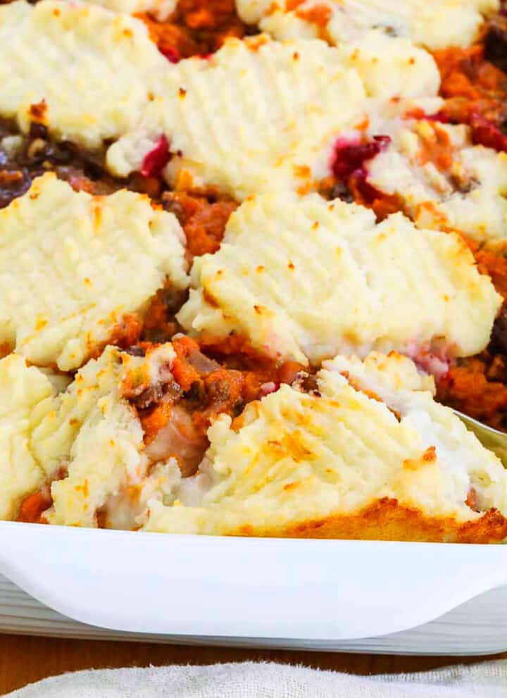 A white dish filled with golden bubbly turkey shepherd's pie baked and ready to eat.