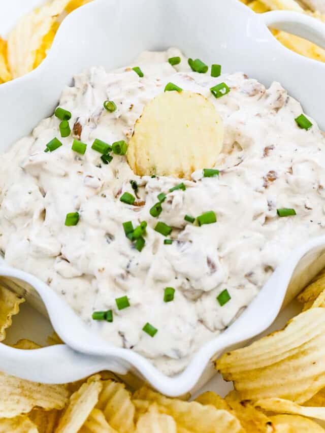 Ruffled potato chips on a plate with homemade French onion dip.