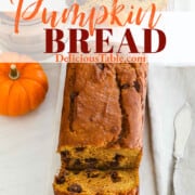 A graphic for a pumpkin bread recipe showing the loaf sliced on a marble cutting board.