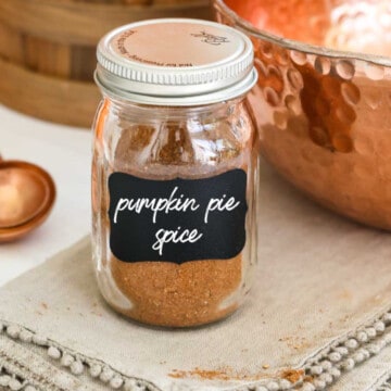 A small glass spice jar filled with pumpkin pie spice made at home.