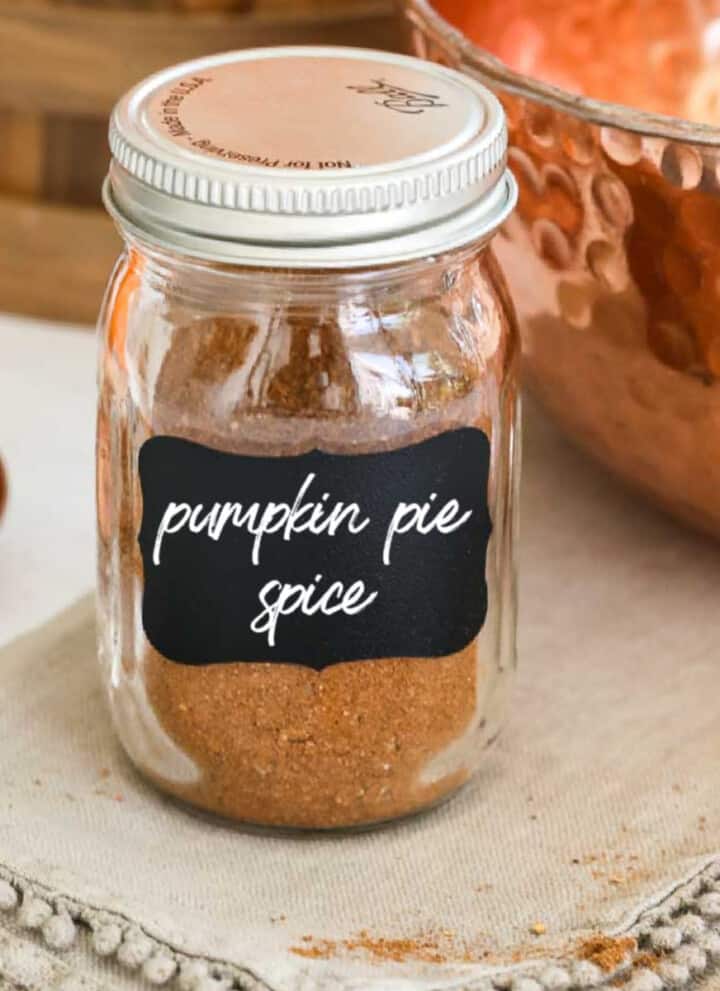 A small glass spice jar filled with pumpkin pie spice made at home.