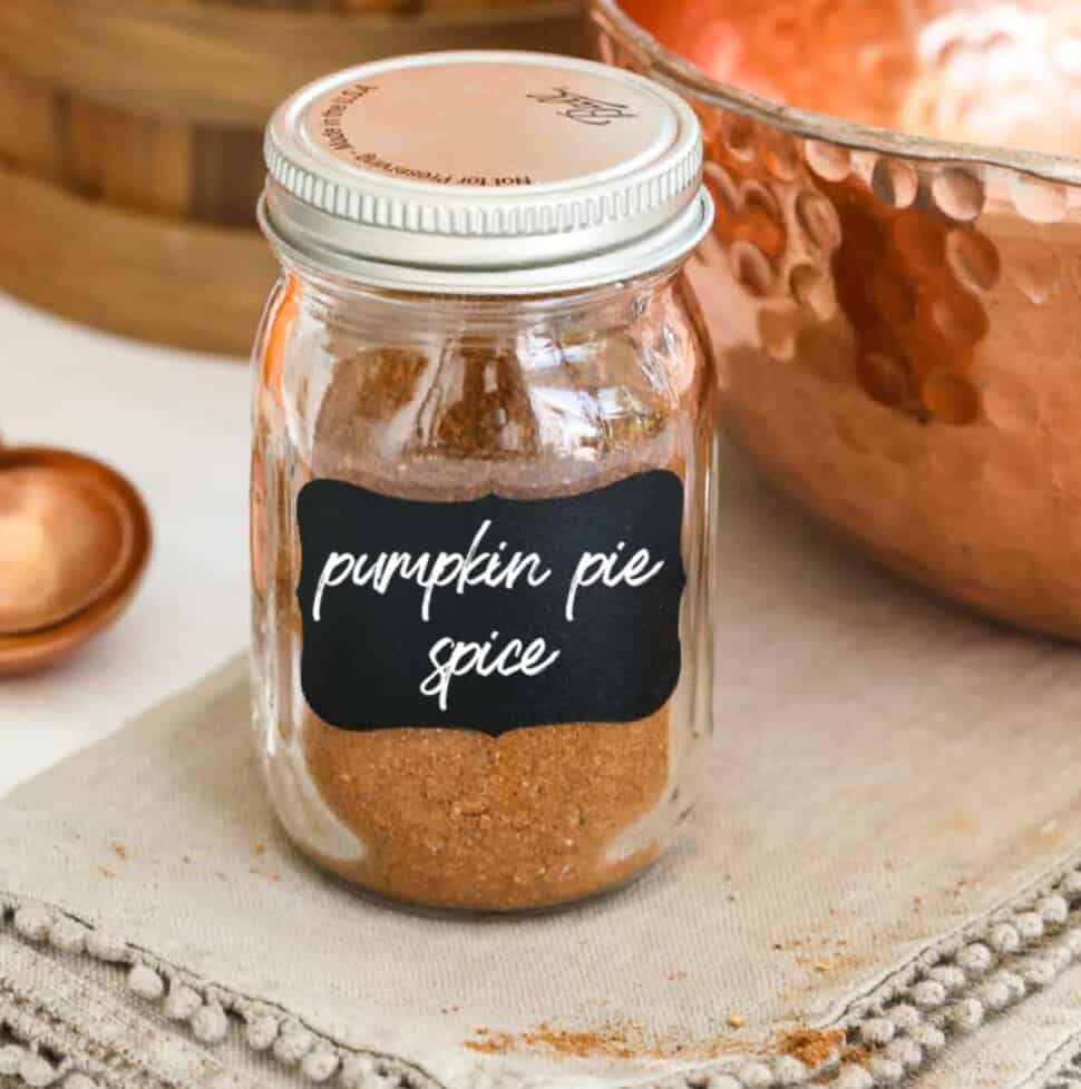 A small glass spice jar filled with pumpkin pie spice made at home.